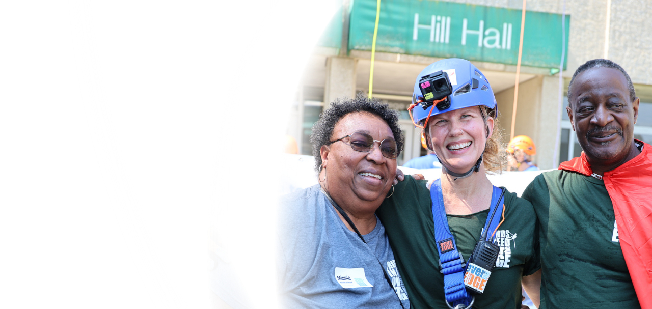 Three smiling Friends In Deed community members at a fundraising event outside Hill Hall